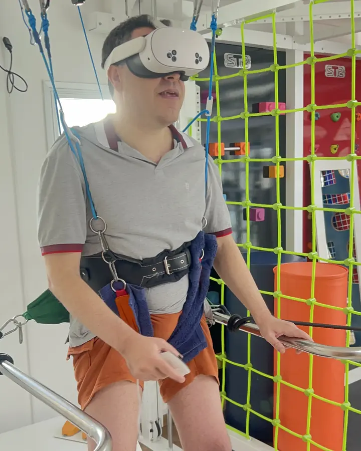 Paciente com óculos de realidade virtual e suspensão parcial de peso
