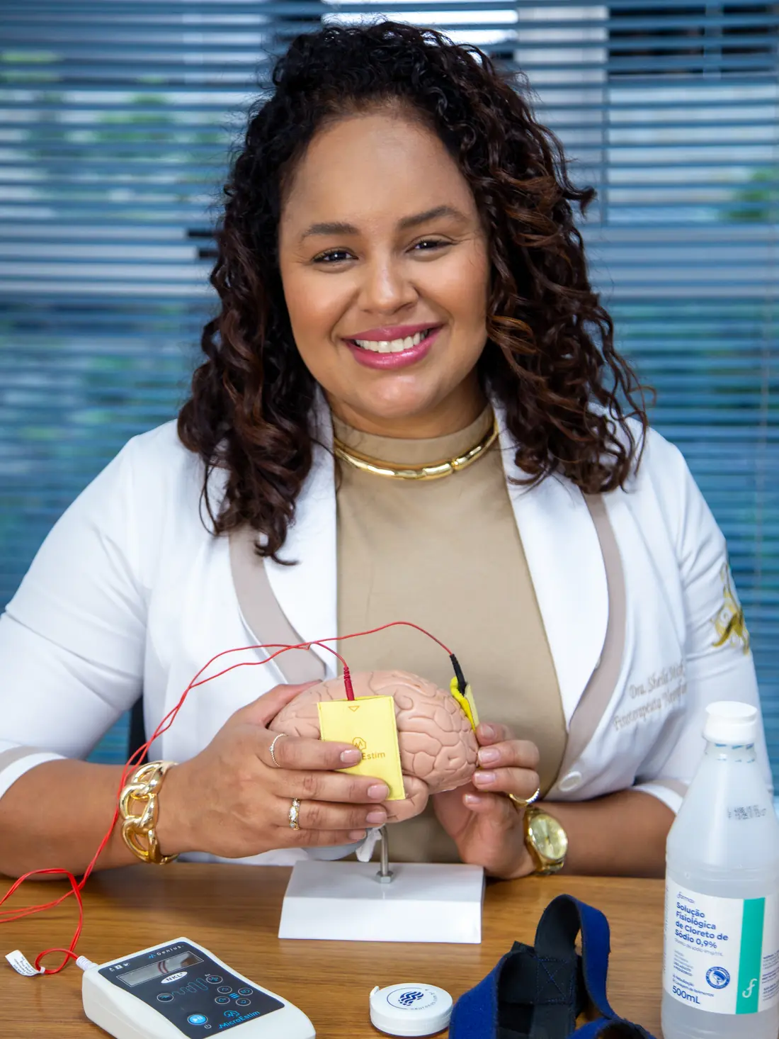 Sheila Misk, fisioterapeuta neurofuncional, segurando um modelo de cérebro com eletrodos de tDCS